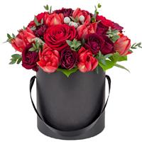 Roses and pion-shaped tulips in a box.
